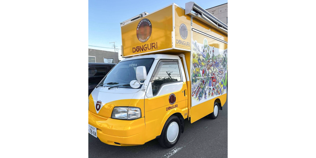 黄色と白の車体に「DONGURI」のロゴとイラストが描かれた、「どんぐり」のキッチンカー。
